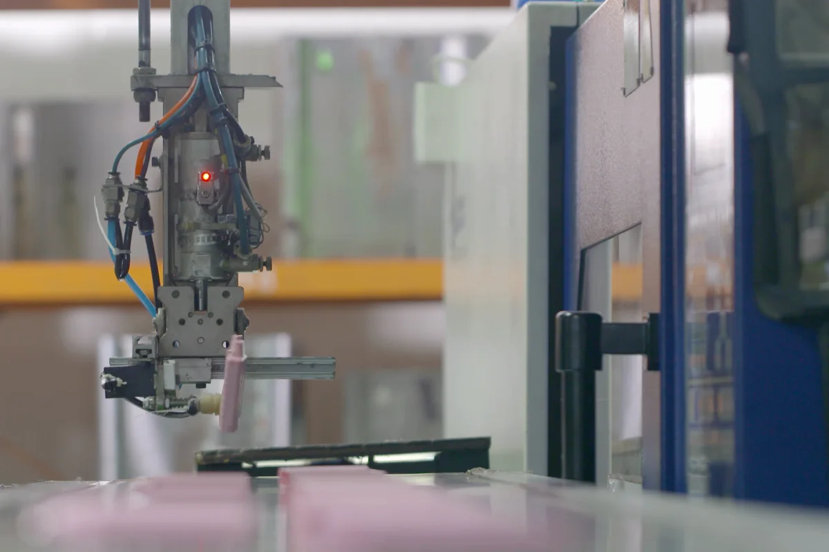 Customer-supplied partner-film still showing automated part take-out during an injection mold trial
