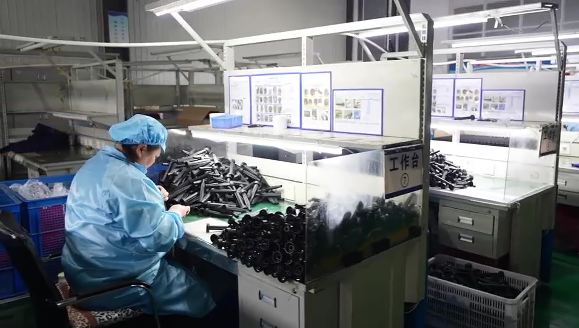 Customer-supplied company-film still showing component inspection at a controlled workbench