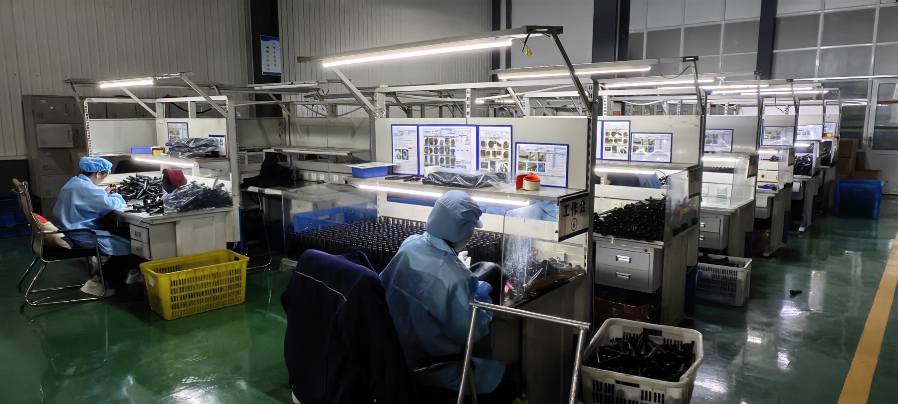 SRRP production operators inspecting components at illuminated workstations